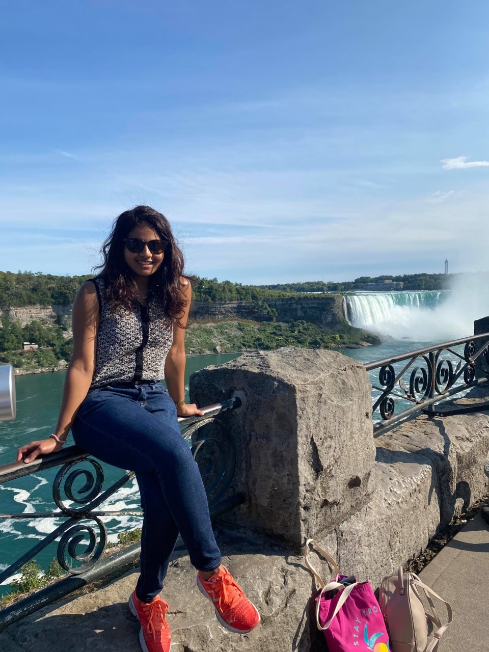 Permanent resident Marushka Loshki Nair sitting on the Niagara Falls railing.