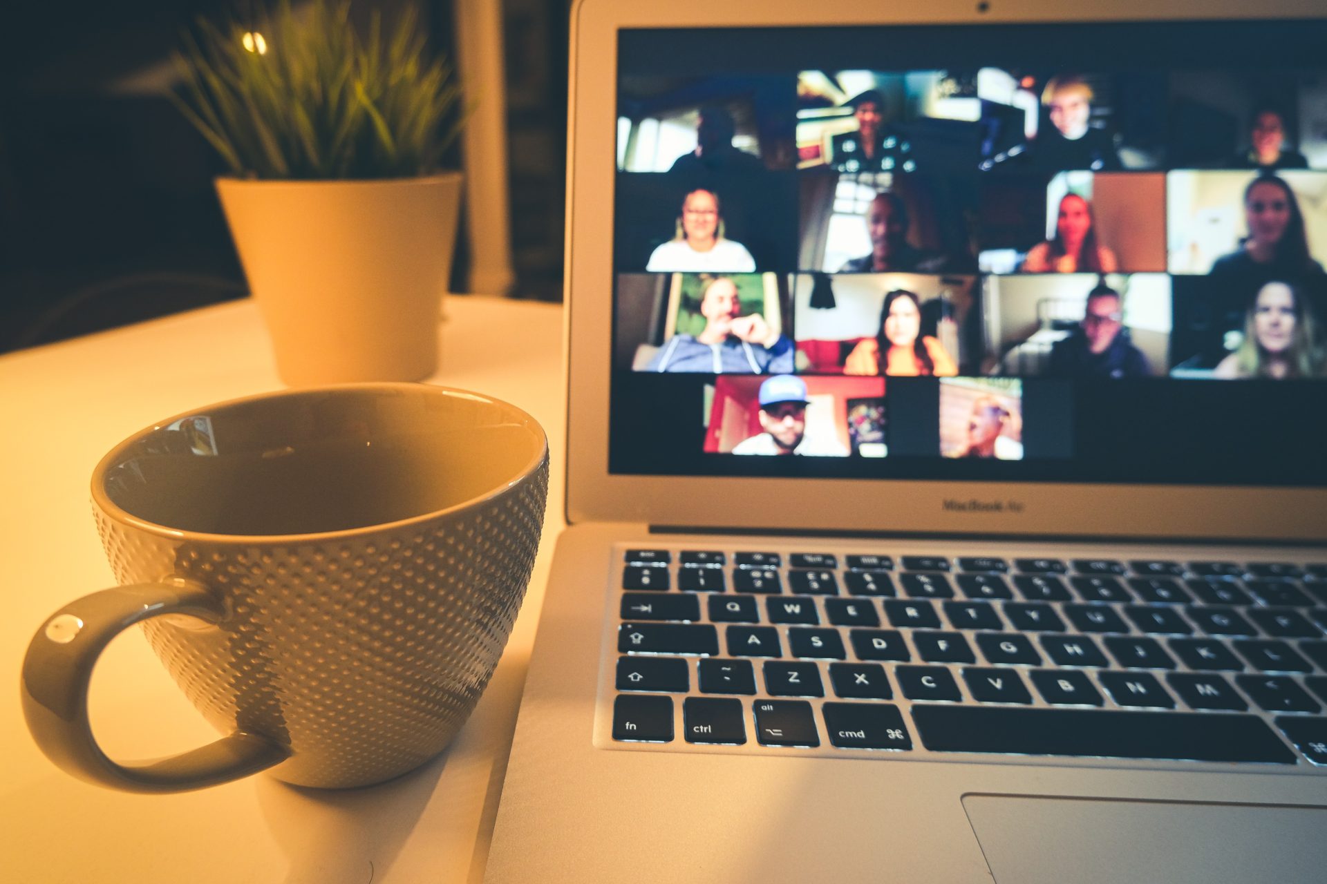 photo of zoom room on laptop screen with coffee mug placed beside it.