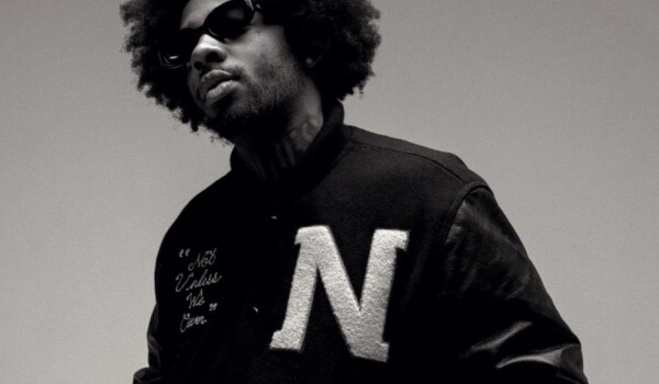 Brent Faiyaz in black and white, wearing a sport jacket